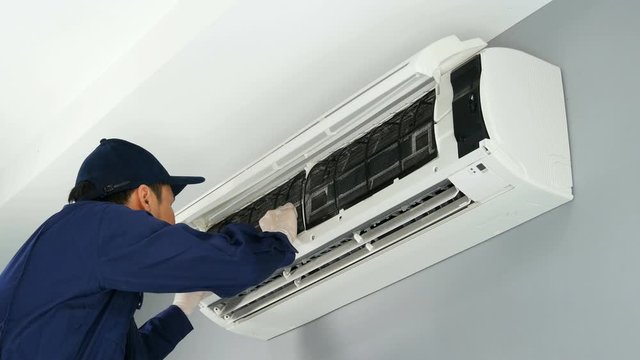 Technician service placing back clean filter into air conditioner