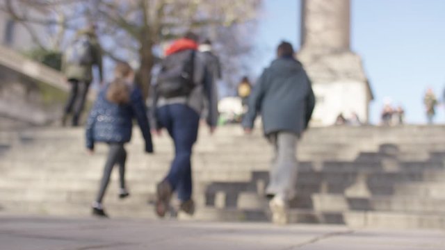 Blurred background of people in the city walking up some steps, in slow motion