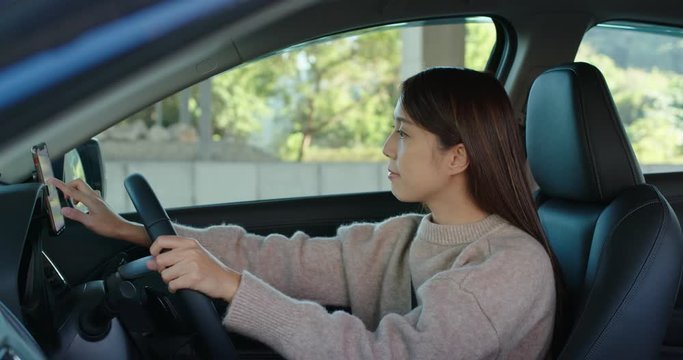 Woman set up the gps location on cellphone inside on car