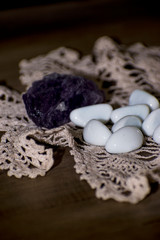 Fototapeta na wymiar Set of small white stones and large black stone on crochet fabric on wooden background