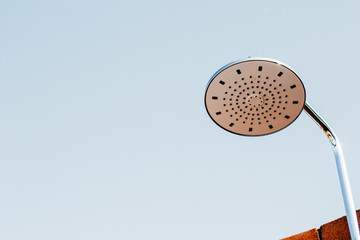 Shower head on red-brown brick walls for outdoor showers. Vintage shower head.