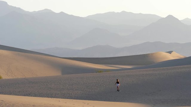 Woman walking in the desert early morning in Death Valley National Park in California, USA