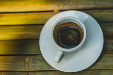 Espresso coffee in white coffee cup on bamboo table background
