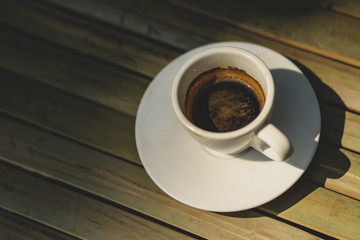 Espresso coffee in white coffee cup on bamboo table background
