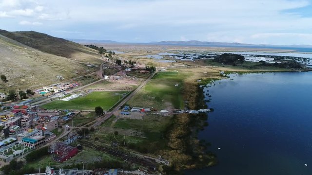 drone movement in the city of Puno over Titicaca lake, Peru