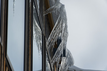 Icicles hang from a roof above a window