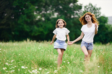 Fototapeta premium mother and daughter running in the field