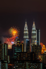 Obraz na płótnie Canvas KUALA LUMPUR, MALAYSIA - 1ST JANUARY 2020; Fireworks explode near Malaysia's landmark Petronas Twin Towers during New Year celebrations in Kuala Lumpur.