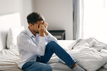 man sitting on sofa and talking on cell phone