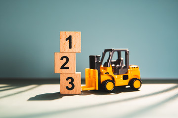 Miniature forklift truck with wooden block number using as business competition concept