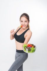 Asian woman portrait with perfect skin smiling face happy wearing black-gray exercise clothing holding a bowl of vegetable salad and fork on white background. Concept healthy.