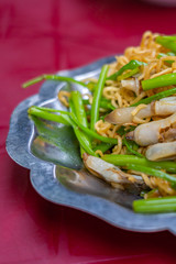 Closeup shot of stir-fried snail noodles and water spinach