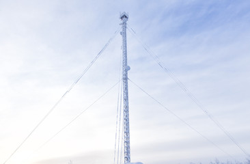 Icy television tower against the sky