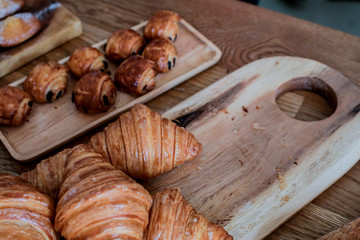 freshly baked croissants on wooden cutting board Warm Fresh Buttery Croissants and Rolls. French and American Croissants and Baked Pastries