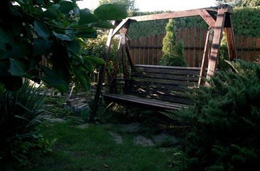 wooden swing in the summer in the garden