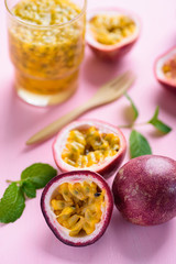 Fresh passion fruit and juice on pink background