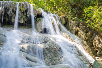 Fototapeta premium Waterfall and blue emerald water color in Erawan national park. Erawan Waterfall, Beautiful nature rock waterfall steps in tropical rainforest at Kanchanaburi province, Thailand