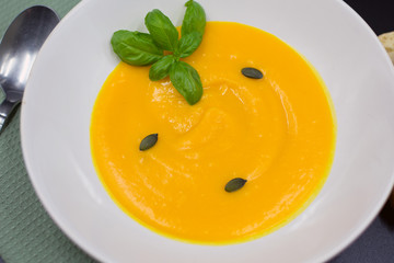 fresh pumpkin soup in plate from close-up view