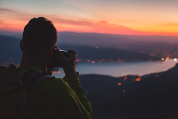 photographer taking photo of night city landscape, travel photography with dslr camera - Powered by Adobe