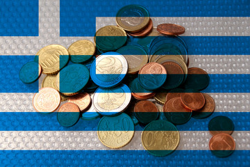 metal coins of the European Union currency against the background of the national flag of Greece, the concept of financial development, devaluation, inflation, taxes