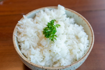 Small bowl of white rice with vegetable decorated on top.