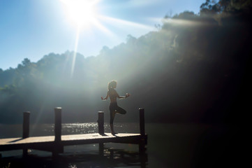 Asia young woman practicing yoga on the lake and sport yoga.