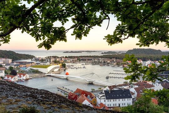 Mandal, Norway - june 2018: Mandal, a small town in the south of Norway. Seen from a height, with a cliff and an oak tree in the foreground.