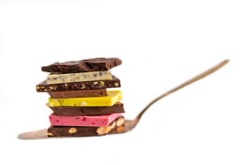 Chocolate pieces, piled on a cake scoop to a pile, white background.