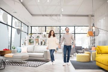 Fototapeta premium Two people looking at furniture models in a modern furniture shop