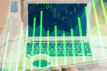 Stock market graph on background with desk and personal computer. Double exposure. Concept of financial analysis.