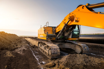 Crane digging a channel for gas pipeline