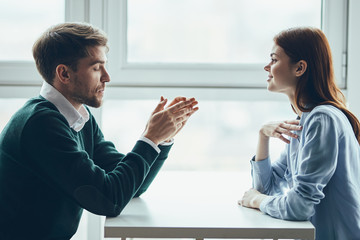 man and woman working on laptop in an office