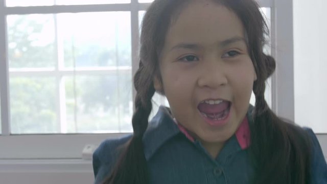 Portrait Of Asian Child Girl Looking At Camera With Smile Face At Home.