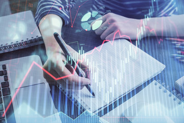 Financial chart drawn over hands taking notes background. Concept of research. Double exposure
