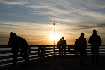 Fototapeta na wymiar Beachgoers watching sunset near Crystal Pier in San Diego