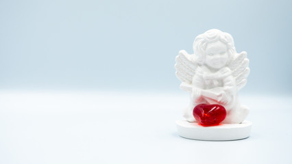 White angel with a red heart on a white background. Valentine's Day.