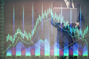 Forex graph with businessman working on laptop on background. Concept of hardworking. Multi exposure.