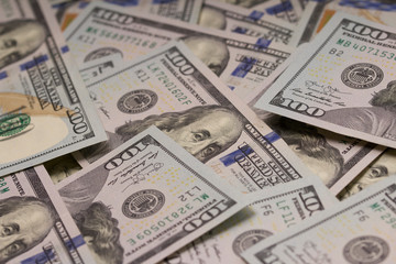  A pile of one hundred US banknotes with president portraits.