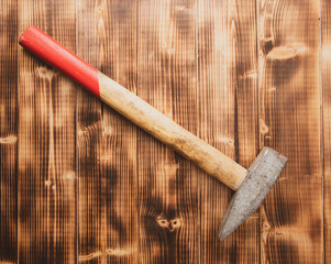 The hammer lies on a wooden background