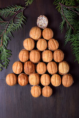 Walnut shaped cookies Oreshki forming a Christmas tree on the dark wooden background