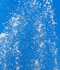 Splashing water from a fountain on a background of blue sky