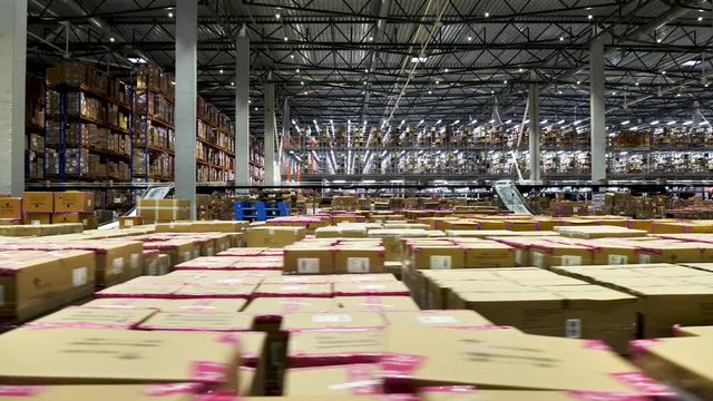 Logistics center interior full of racks with large number packs cardboard boxes