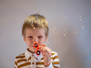 Funny blond child in striped shirt twists spinner on his nose. 4K