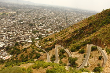Top view of a city with loop of roads on hillside
