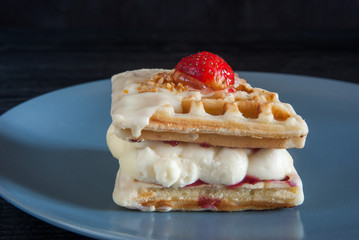 Belgian waffle cake on gray plate on  black background
