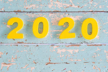 The yellow wooden number letters signify year 2020 placed on old vintage wooden.New year change to 2020 concept