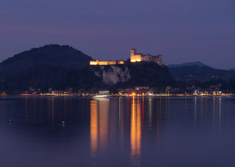 Naklejka premium the Lombard shore of Lake Maggiore and the Borromea fortress at night time viewed from Arona.Italy