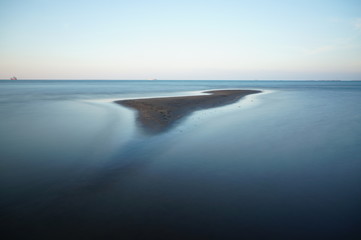The beach in the afternoon has a relaxed atmosphere and the sea experiences low tide