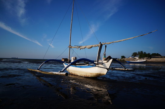 Traditional fishing vessels that still use traditional fishing gear, this boat is made of wood that is resistant to sea water. Fishing boats dock at the seashore. © PUGUH