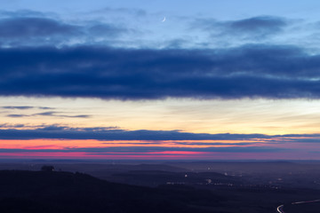 The moon waits for a colorful sunset.
